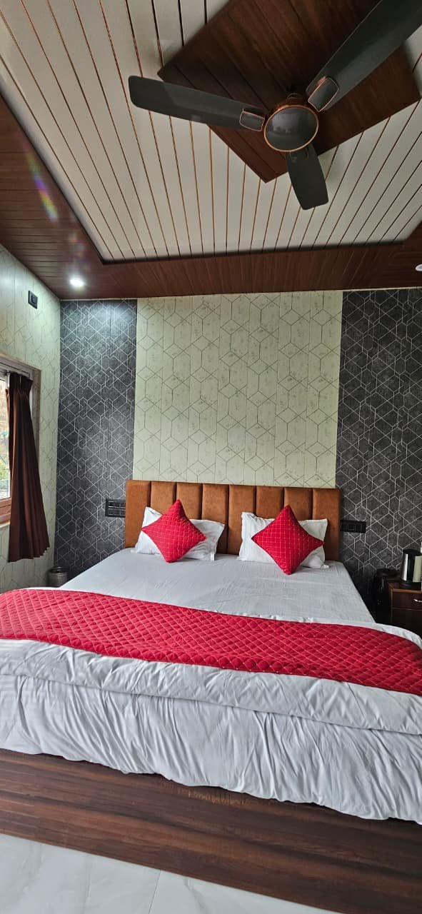 Deluxe room with double bed, wood ceiling, hex wallpaper feature wall