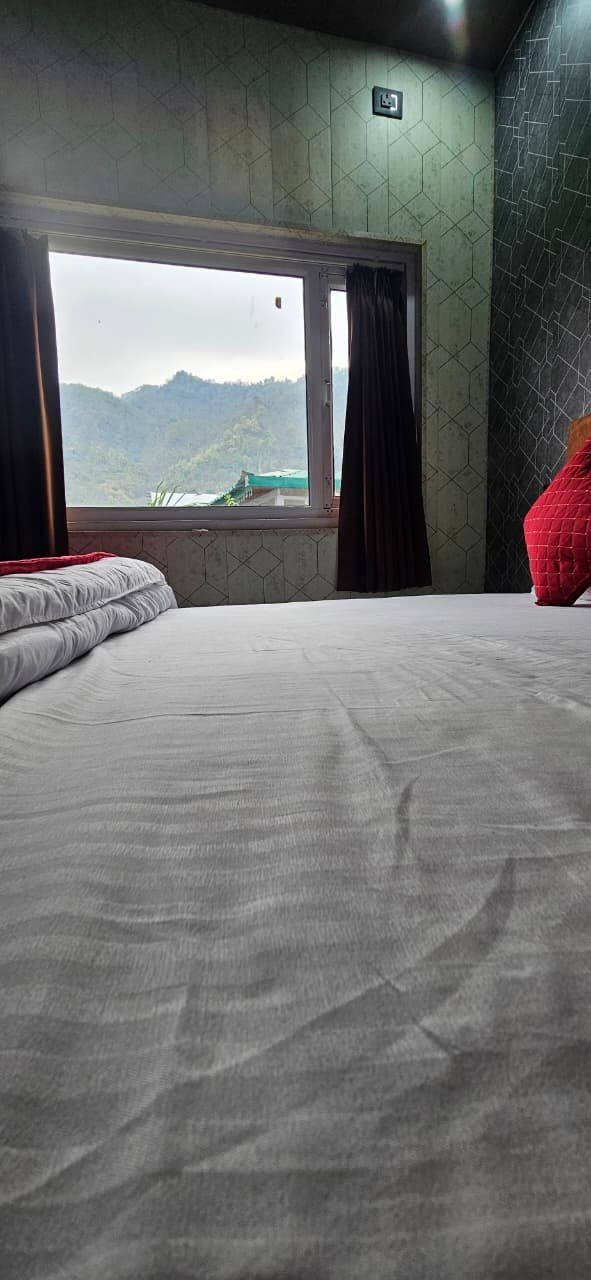 Bed with picture-window view of the Himalayan foothills