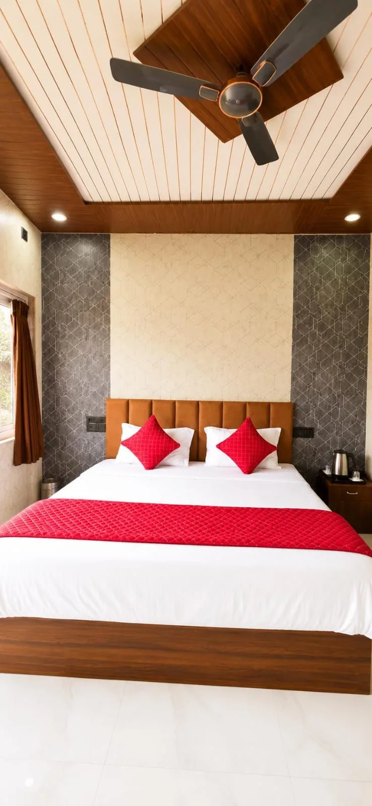 Deluxe room with red bedding and textured feature wall