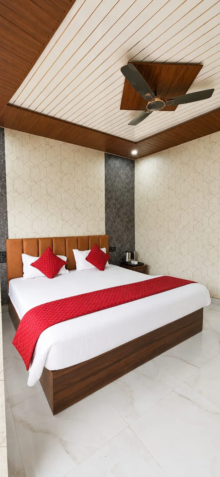 Comfortable room with red bed runner and wood ceiling