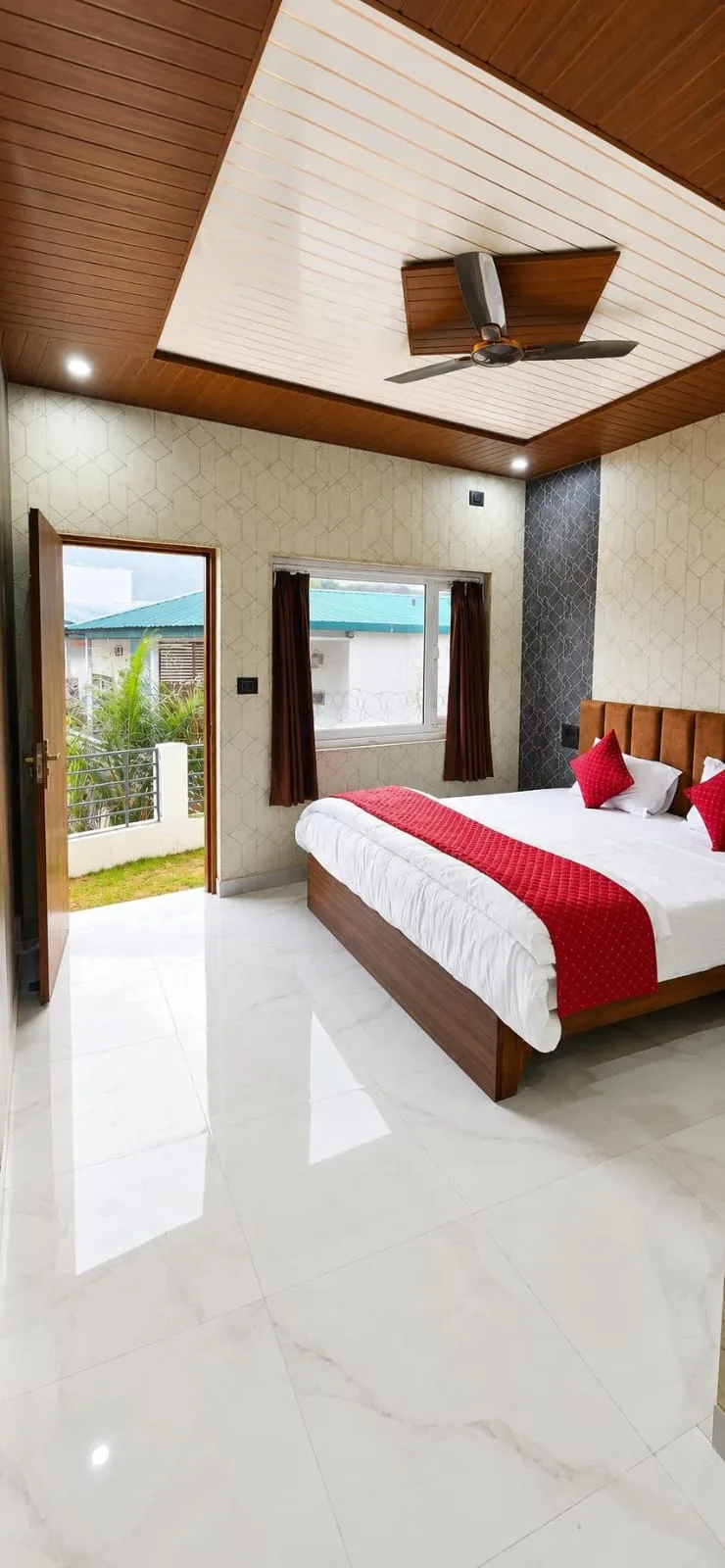 Spacious room with red bedding and balcony access